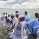 A woman reacts as senior members of the Apostles Of Muchinjikwa Christian church baptize members during a mass baptism (Jorodhani) on the beachfront on Southend-on-Sea, Britain.